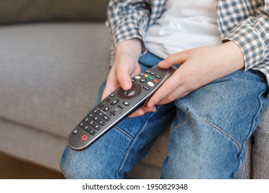 Close-up Kid Hands Holding TV Remote Controller. Boy Without Parental Control Watching Television. Early Childhood Education And Elementary Age Leisure.