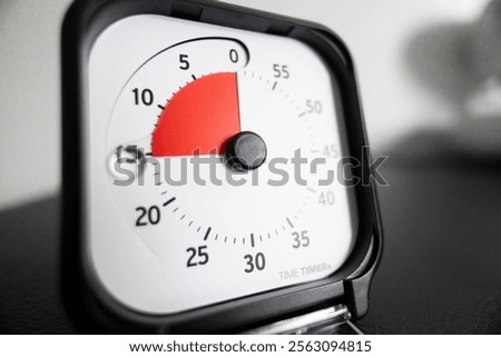 Close-up of a kitchen timer showing a few minutes left. The red segment indicates time remaining.