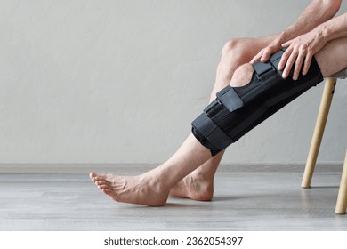 Closeup of knee brace to patient leg on background with copy space - Powered by Shutterstock