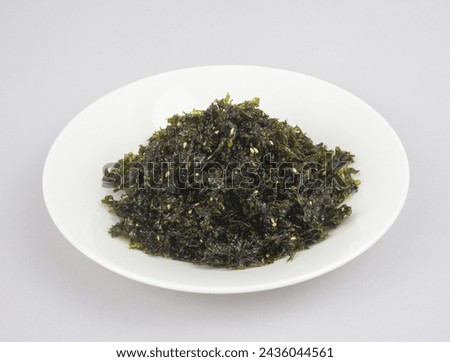 Close-up of Korean food Kim Jaban(dried seaweed sprinkles) with sesame seeds on dish and white floor, South Korea
