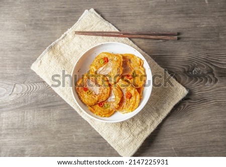 Close-up of Korean Food Kimchi Jeon(Kimchi Pancake) on a round ceramice plate and cloth with chopsticks, South Korea
