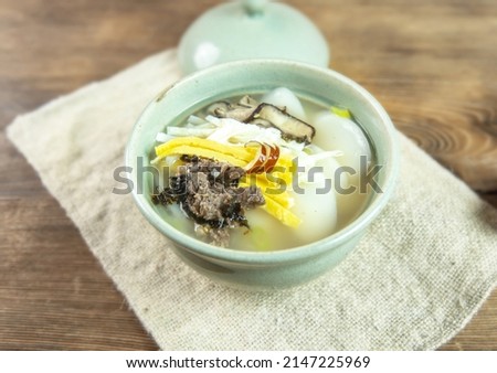 Close-up of Korean Food Tteokguk(rice-cake soup) with beef, egg garnish and shiitake mushroom, bowl, South Korea
