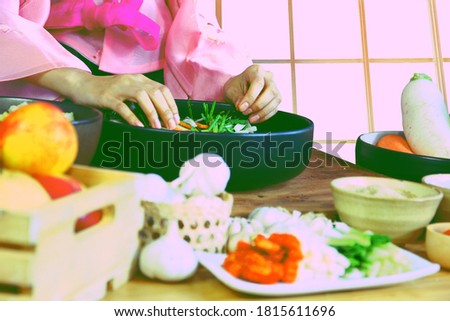 closeup Korean woman in hanbok national costume is cooking kimchi preserving vegetables to eat in winter