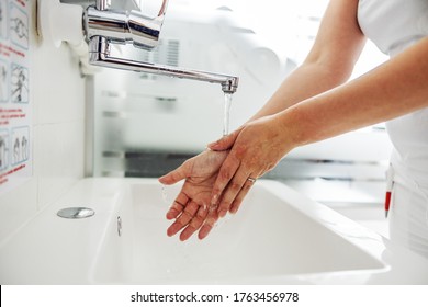 Closeup of lab assistant washing her hands while standing in laboratory.