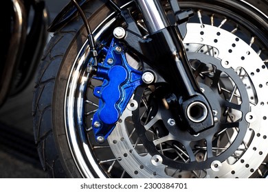 Close-up of laced wheel of motorcycle caferacer at parking lot during sunset - Shutterstock ID 2300384701