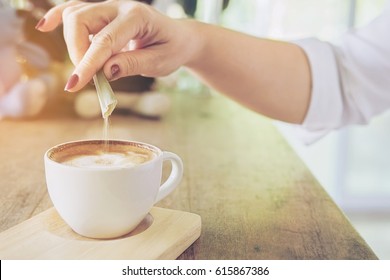 Closeup Of Lady Pouring Sugar While Preparing Hot Coffee Cup