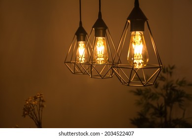 Close-up Of A Lamp Inside A House. The Bulb Is On And Generating Light. Electricity