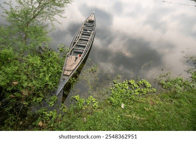 Closeup landscape the boat of Bangladesh. Rural local hand made wooden boat of Bangladesh is Also known as Dingi nouka in Bengali. Boats are kept near the river bank to cross the river in a village.  - Powered by Shutterstock