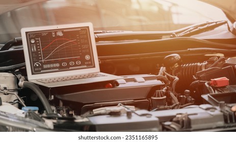 closeup laptop computer with racing car engine ecu speed tuning with modern software display torque and horsepower on screen
