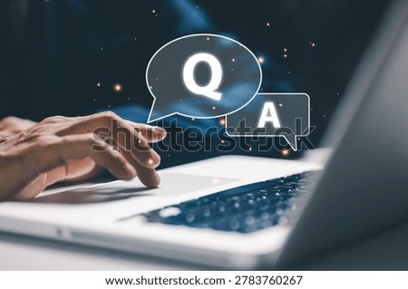 Closeup of laptop user with virtual question and answer speech bubbles, representing online support, customer service, FAQ communication and digital assistance technology.