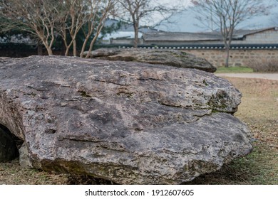 Closeup of large boulder used as capstone on dolmen tomb with slightly blurred in background.
