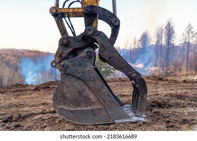 Close-up Of Large Bucket Of  Heavy Excavator Loader Against Background Of Forest Fire. Smoke. Natural Disaster In Nature.