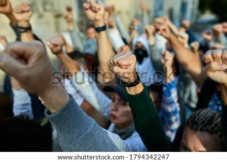 Close-up of large group of people with raised fists on public demonstrations. 