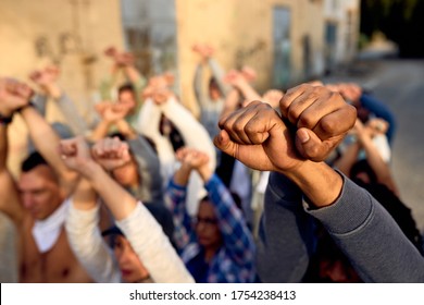 Close-up of large group of protesters with clenched fists above their heads on public demonstrations. 