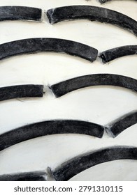 Close-up of a large tire tread pattern with deep grooves and curved rubber segments.