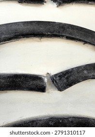 Close-up of a large tire tread pattern with deep grooves and curved rubber segments.