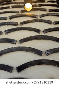 Close-up of a large tire tread pattern with deep grooves and curved rubber segments.