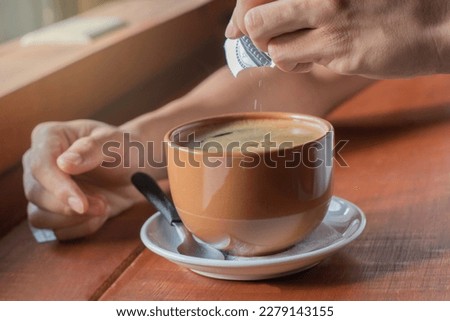 close-up of latin man pouring sweetener into his coffee, healthy lifestyle