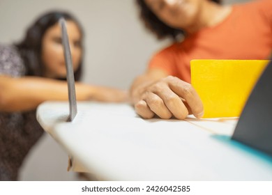 Close-up of latin young female and male work partners checking the symmetry level of a surfboard in workshop - Powered by Shutterstock