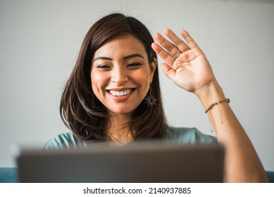 Close-up Of Latina Teacher Greeting Her Class On A Video Call At Home