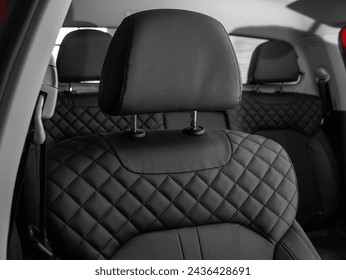  Close-up  leather black  rear seat made of  in the background passenger seats with seat belts. Luxury car interior - Powered by Shutterstock