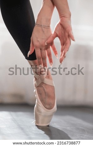 Close-up of the legs and arms of a ballerina.