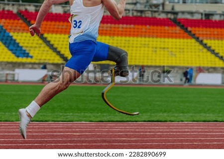 close-up legs athlete runner on prosthesis running stadium track, disabled athlete para athletics competition, summer sports games