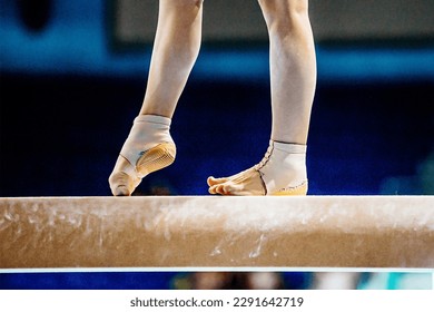 close-up legs female gymnast step on balance beam in gymnastics, fitted neoprene ankle support with heel cup - Powered by Shutterstock