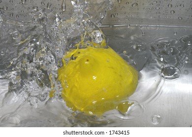 Closeup Of A Lemon Spashing Into A Pool Of Water