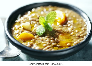 closeup of lentil soup, the lentils have cooked for 3 hours in order to form its own thick sauce, it also has carrots and onions