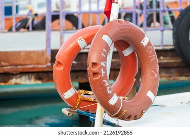 close-up lifebuoy on a boat. Red lifebuoy on ship railing with sea surface 