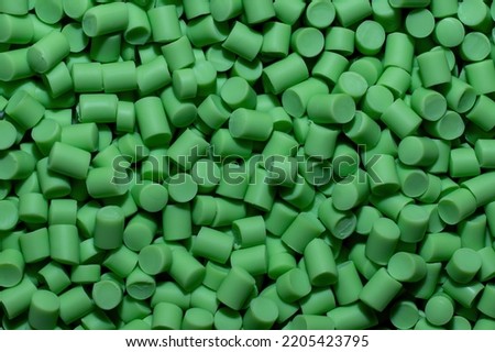Close-up of light green plastic polymer granules. polymer plastic. compound polymer. PVC resin compounds. Tinted plastic granulate for injection moulding process
