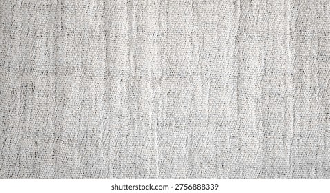 Close-up of a light-colored fabric surface featuring a subtle woven pattern with fine texture and soft neutral tones.