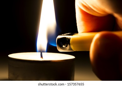 Closeup Of Lighting A Tee Candle With A Lighter.