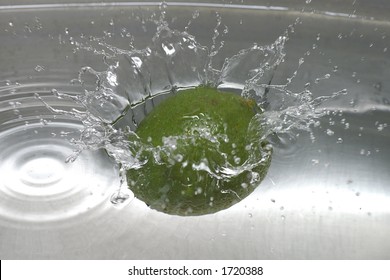 Closeup Of A Lime Spashing Into A Pool Of Water