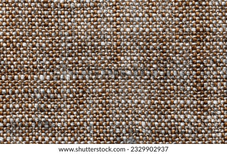 Close-up of linen fabric. Gray and brown textile background of intertwined natural threads. The basis for making breathable, light, fashionable summer clothes. Flat lay, macro, top view, mockup