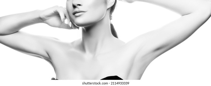 Close-up lips, and shoulders of young caucasian girl with natural make-up, perfect skin touch her skin isolated on white background. Studio portrait. Monochrome