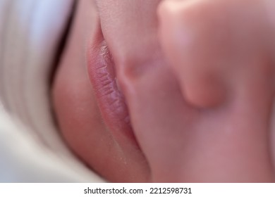 Closeup Of The Lips Of A Tiny Newborn Baby Asleep In His Crib. Selective Focus