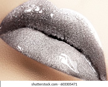 Close-up of liquid silver woman lips with glittering silver. Glittering Lips. Fashion Make-up