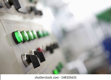 Closeup of lit lights and control dials on manufacturing machinery - Powered by Shutterstock