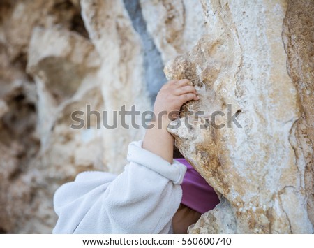 Little boy looking through the wall of a castle