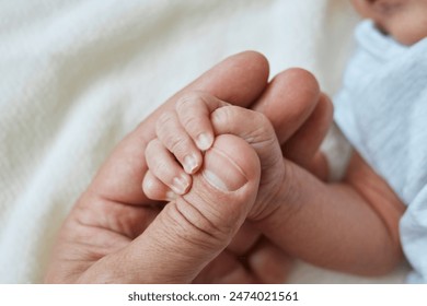 Close-up little hand of child and finger of father, newborn baby has firm grip on the parent's finger after birth, infant holding on to dad's hand - Powered by Shutterstock