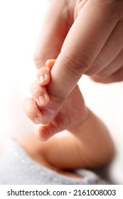 Close-up little hand of child and palm of mother and father. The newborn baby has a firm grip on the parent's finger after birth. A newborn holds on to mom's, dad's finger. - Shutterstock ID 2161008003