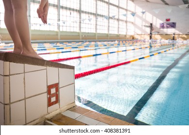 Closeup of  little kid's feet on the pool's side. Boy in the sport swimming pool. Training for competition. Sport activities for children.