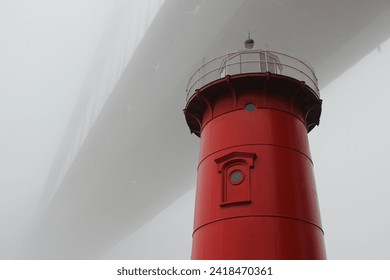 Close-up of the Little Red Lighthouse under the George Washington Bridge surrounded by thick fog on a winter day in Fort Washington Park, Washington Heights, New York City - Powered by Shutterstock