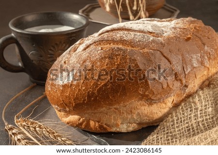 Close-up of a loaf of freshly baked homemade bread on the table. Whole-grain white bread. Healthy food, bread on sourdough. Close-up.
