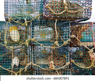 Closeup of lobster pots, ropes and buoys stacked on top of each other on a dock in Maine.