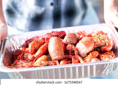Closeup Of Lobsters And Crawfish Seafood With Hands Holding Tray Of Red Shellfish In New Orleans Street Food