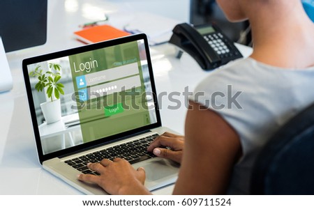 Close-up of login page against woman working on laptop while sitting on chair