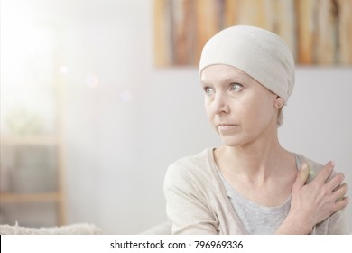 Close-up Of A Lonely, Weak And Sick Woman With Cancer Sitting At Home Alone